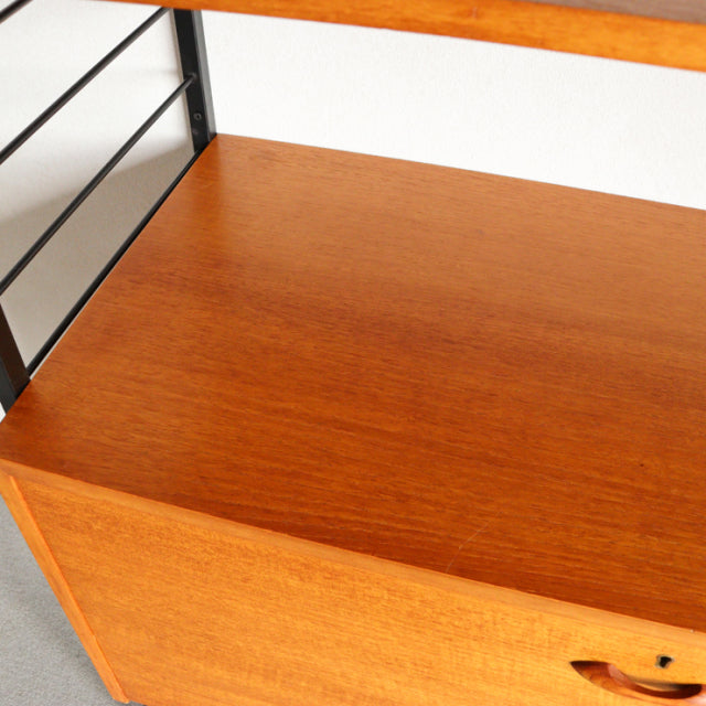 Mid-century vintage British teak Ladderax shelving unit with smooth wood grain and metal side frame.