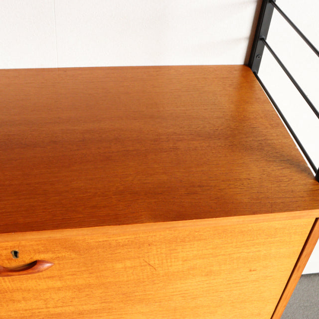 Mid-century British Ladderax vintage teak shelf with rich wood grain and black metal frame detailing.