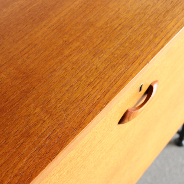 Vintage teak Ladderax shelf unit corner with smooth wood grain and rounded recessed handle, British mid-century design.