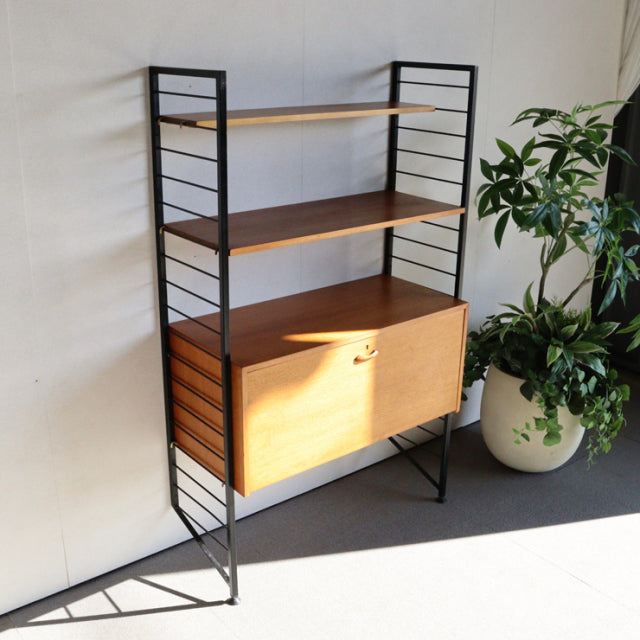 Vintage teak Ladderax unit shelf by Staples featuring black metal frame, three shelves with rich wood grain, mid-century.