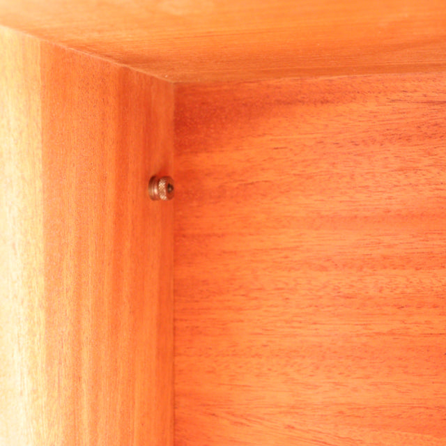 Close-up of vintage teak wood grain inside Ladderax shelving unit showing smooth mid-century finish and metal connector.