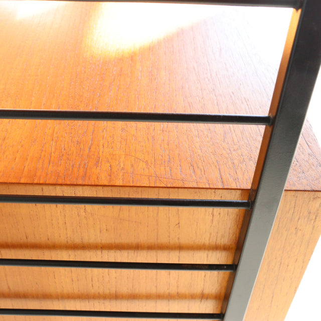 Vintage Ladderax shelving unit featuring rich teak wood grain with sleek black metal frame, British mid-century design from.