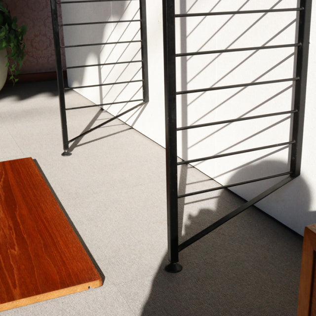 Mid-century British Ladderax shelving unit with vintage teak wood shelf and black iron frame showcasing clean lines and wood .