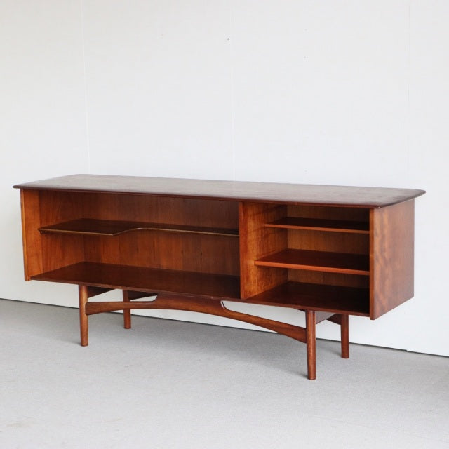 Mid-century British teak sideboard by Dalescraft with rich wood grain, open shelving, and sculpted legs.