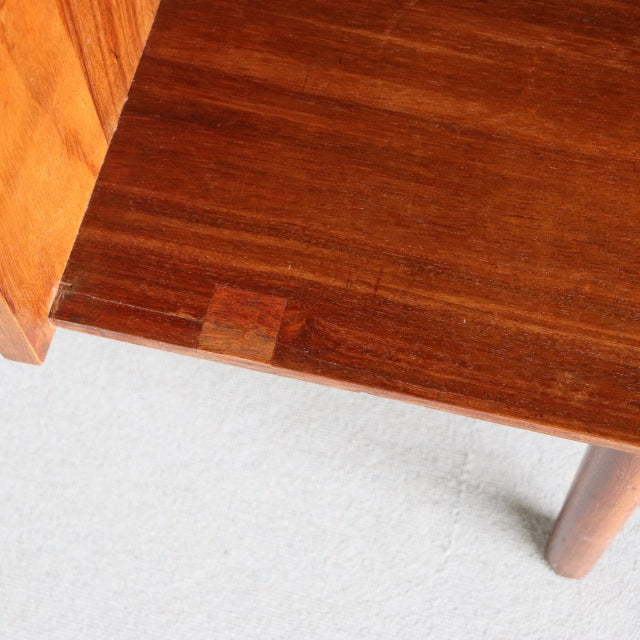 Close-up of vintage mid-century British teak sideboard corner showing rich wood grain, smooth finish, and rounded leg detail.