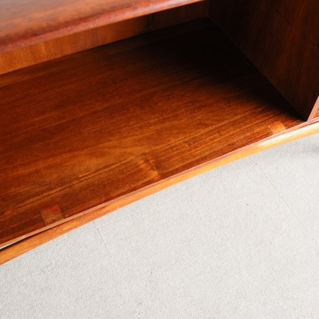 Close-up of vintage British teak sideboard interior showing rich wood grain and mid-century craftsmanship with smooth finish .