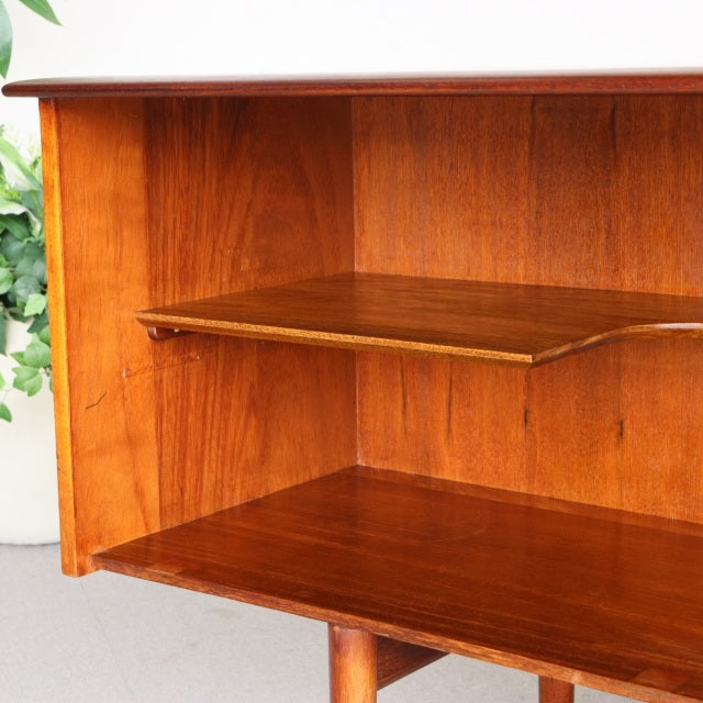 Mid-century vintage British teak sideboard interior with rich wood grain and adjustable shelf, Danish-inspired legs visible.