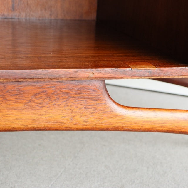 Close-up of vintage teak sideboard corner showing smooth wood grain and curved mid-century British design detail from.