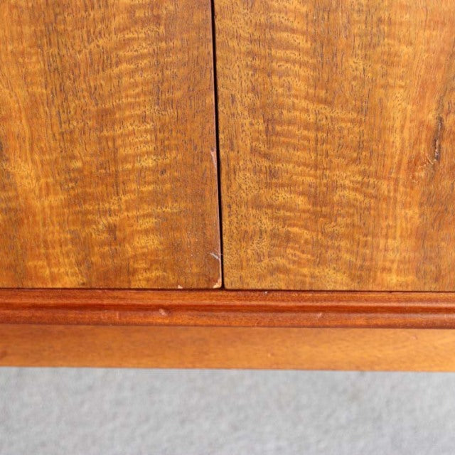 Close-up of vintage mid-century teak sideboard door with rich wood grain and warm British-Denmark design details.