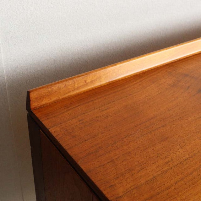 Close-up of vintage teak sideboard top corner with raised edge, showcasing warm wood grain and smooth mid-century British.