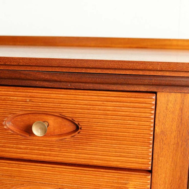 Vintage teak mid-century sideboard drawer with oval brass handle and detailed wood grain, British-Danish design.