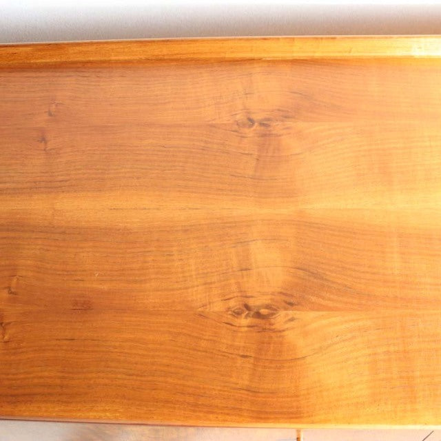 Close-up of vintage teak wood grain on mid-century British sideboard by Robert Heritage, smooth polished surface.