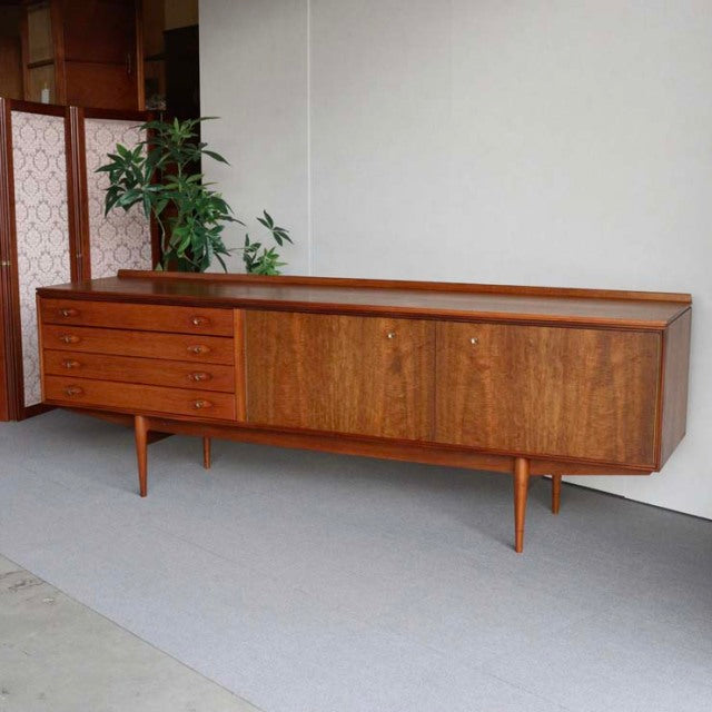Mid-century British vintage teak sideboard by Robert Heritage, featuring rich wood grain, four drawers on left, sliding.