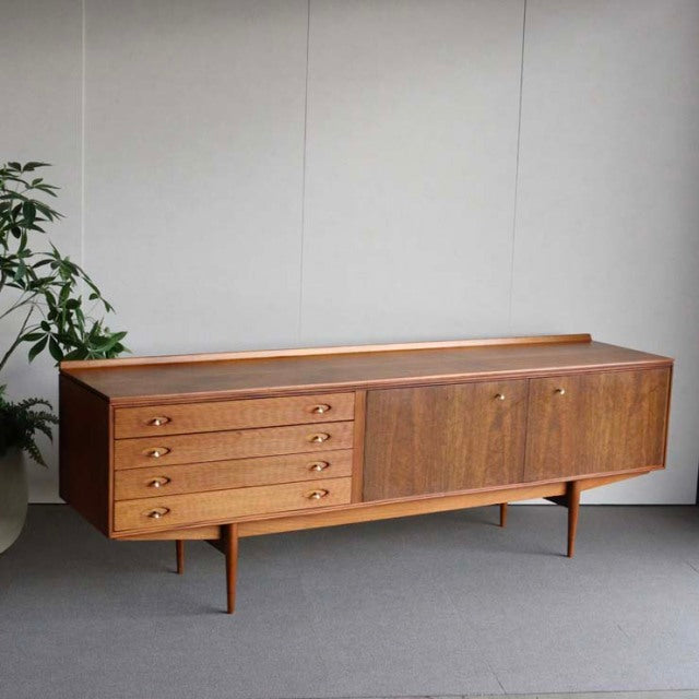 Mid-century British vintage teak sideboard by Robert Heritage with four drawers and two cabinet doors on slender legs,.