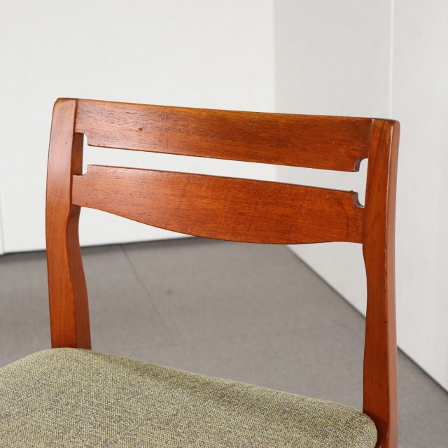 Vintage teak dining chair by Nathan featuring mid-century British design with curved backrest and natural wood grain,.