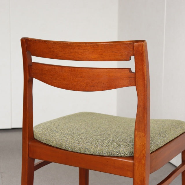 Vintage mid-century British Nathan dining chair in teak with curved backrest and green upholstered seat.