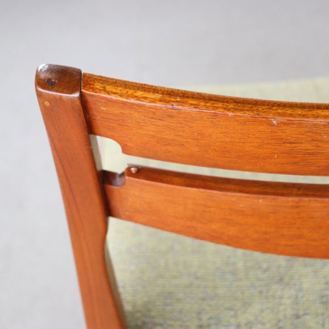 Mid-century British vintage teak dining chair backrest with smooth wood grain and sturdy vertical legs.