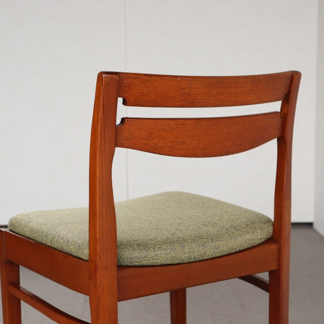 Vintage teak dining chair by Nathan with smooth mid-century British design, curved backrest, and light green upholstered seat.