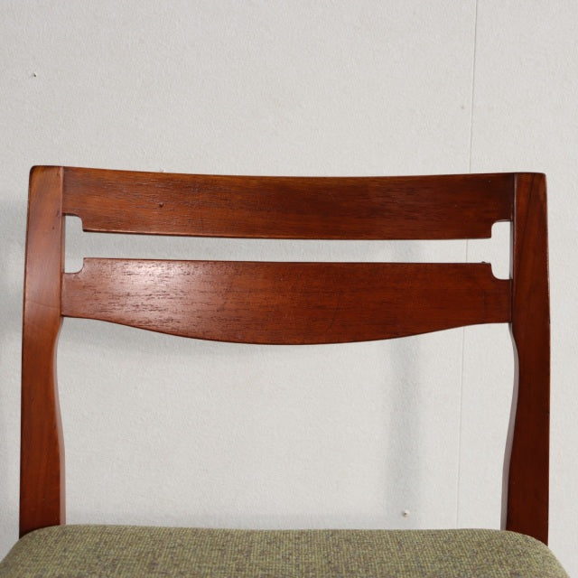 Mid-century British vintage teak dining chair backrest with rich wood grain and curved design.