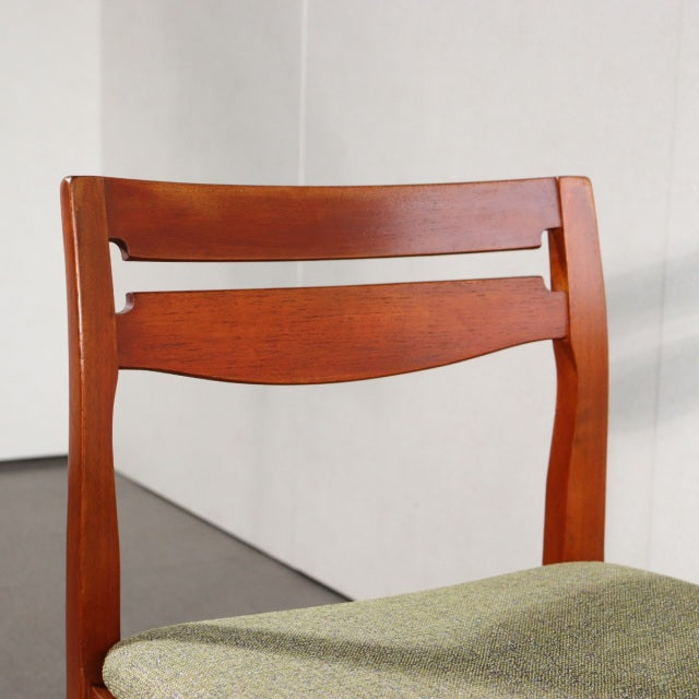 Vintage teak dining chair with British mid-century design, curved backrest, and green upholstered seat from Denmark style.