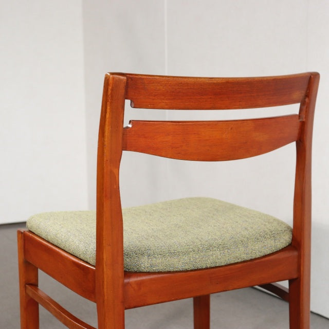Vintage teak dining chair by Nathan with mid-century British design, curved backrest, and green upholstered seat.