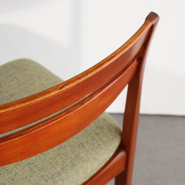 Mid-century British dining chair with teak wood frame, visible grain, and green upholstered seat, vintage Denmark style.