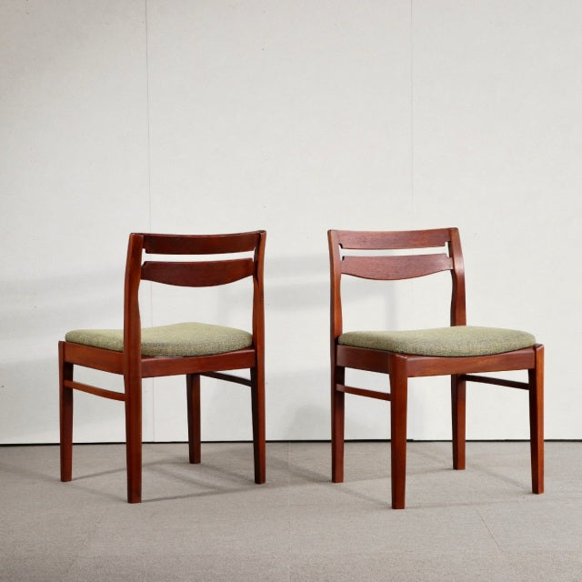 Pair of vintage mid-century NATHAN dining chairs in teak with olive green upholstered seats, British-Danish design, visible.