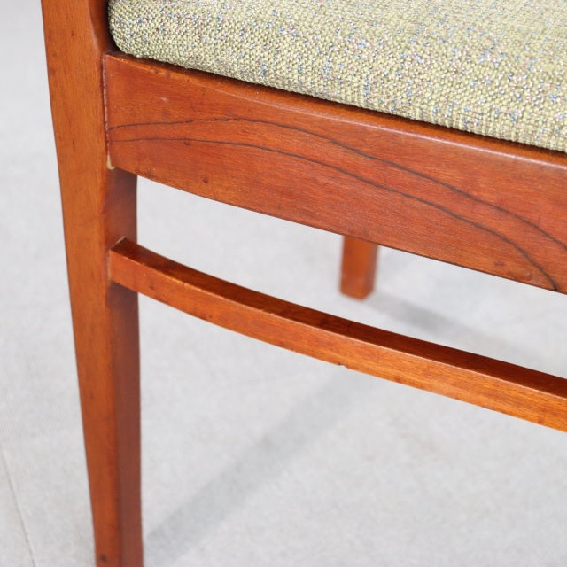 Vintage teak mid-century dining chair leg and frame detail showing warm wood grain and Danish British design craftsmanship.