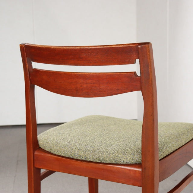 Vintage teak mid-century British dining chair by NATHAN with curved slat back and green upholstered seat.