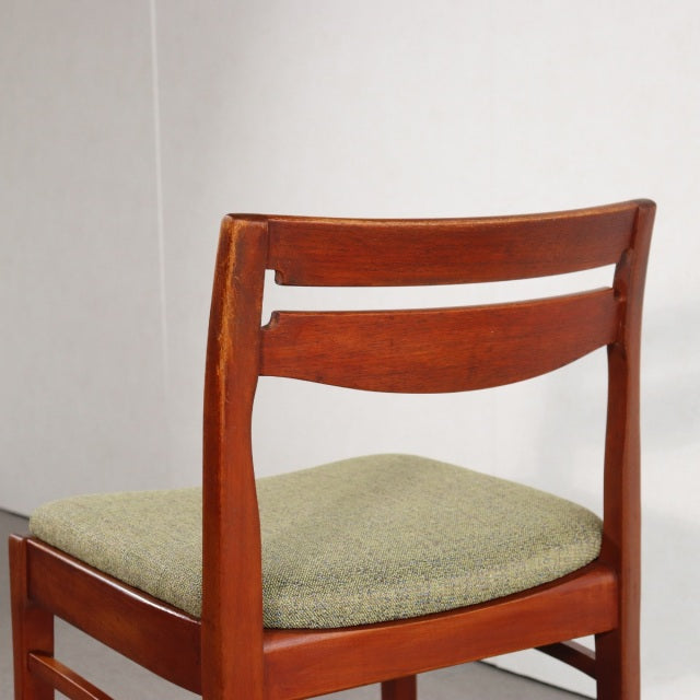 Vintage teak dining chair by NATHAN with mid-century British design, curved backrest, and green upholstered seat cushion.