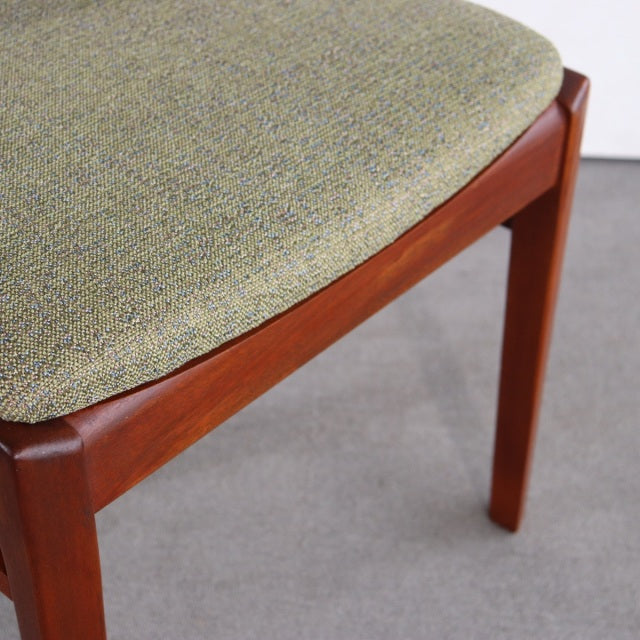 Mid-century British vintage teak dining chair leg with green textured fabric seat and clean wood grain.