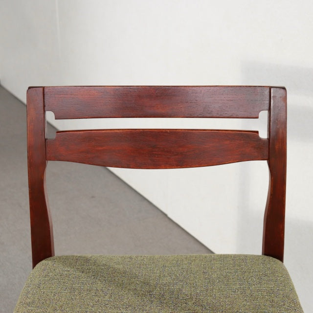 Mid-century British dining chair by NATHAN in vintage teak with curved slatted backrest and green upholstered seat.