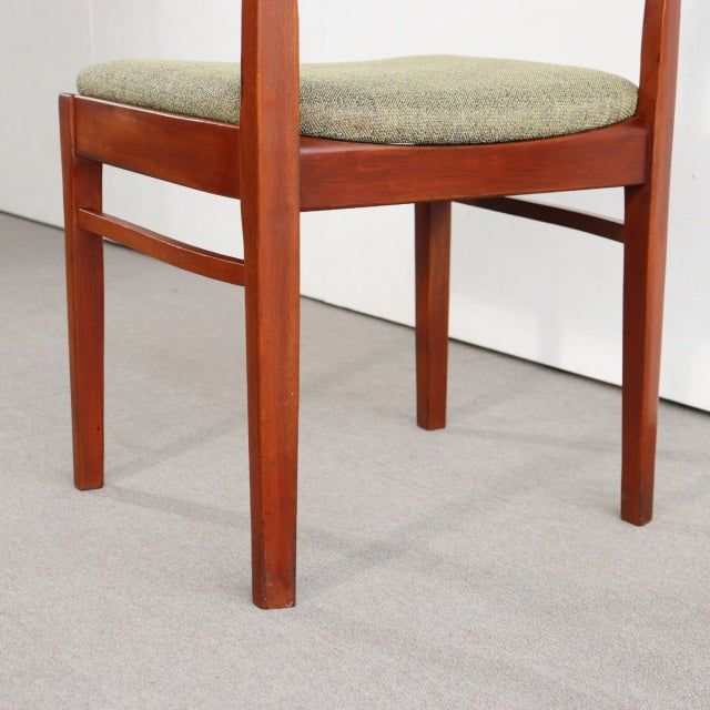 Mid-century British vintage teak dining chair with tapered legs and green upholstered seat cushion.