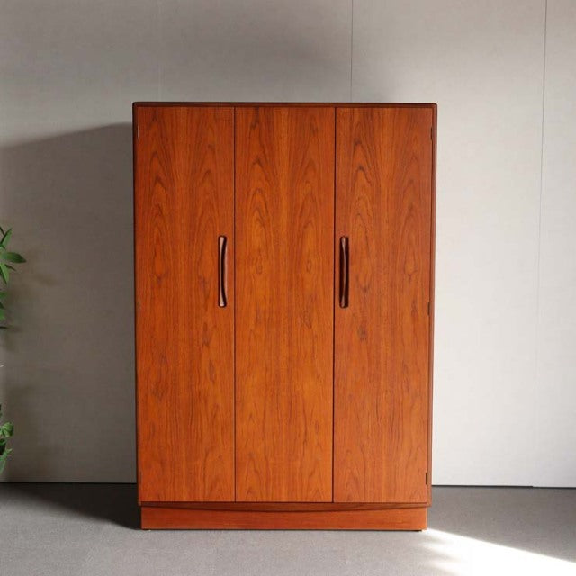 Mid-century British G-Plan teak wardrobe with rich wood grain, sleek vertical handles, and clean-lined form.