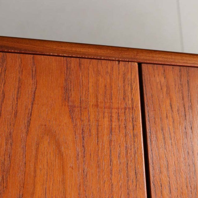 Close-up of vintage British mid-century teak wood wardrobe door panels showing rich wood grain and smooth finish.