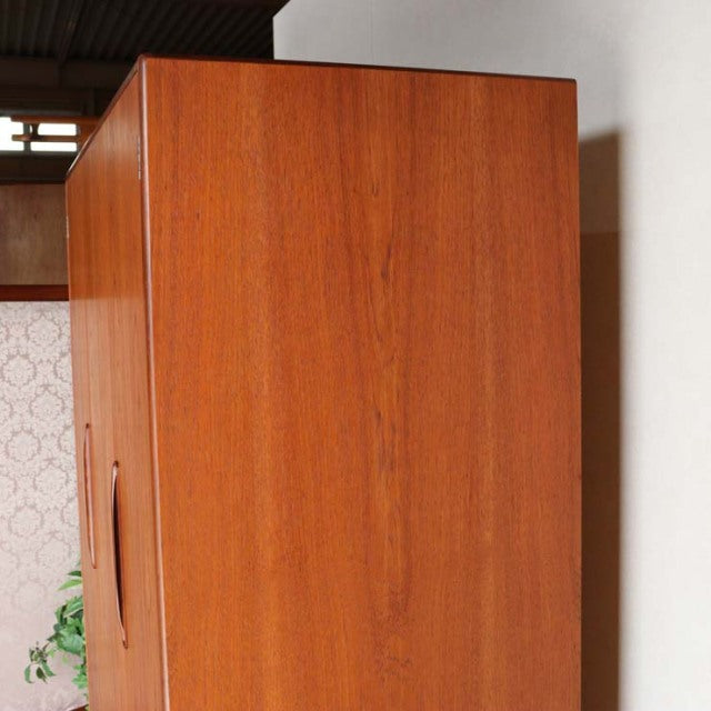 Vintage teak British mid-century G-Plan wardrobe with smooth wood grain and sleek vertical handles.