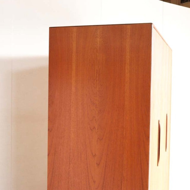 Vintage G-Plan teak wardrobe with smooth wood grain, mid-century British design, and minimalist handles on side panels.