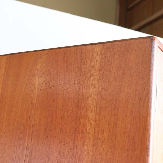 Corner close-up of vintage British mid-century G-Plan teak wardrobe showing smooth wood grain and sharp edges.