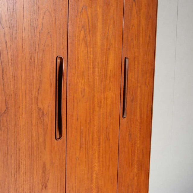 Vintage British mid-century teak G-Plan wardrobe with smooth wood grain and integrated vertical handles.