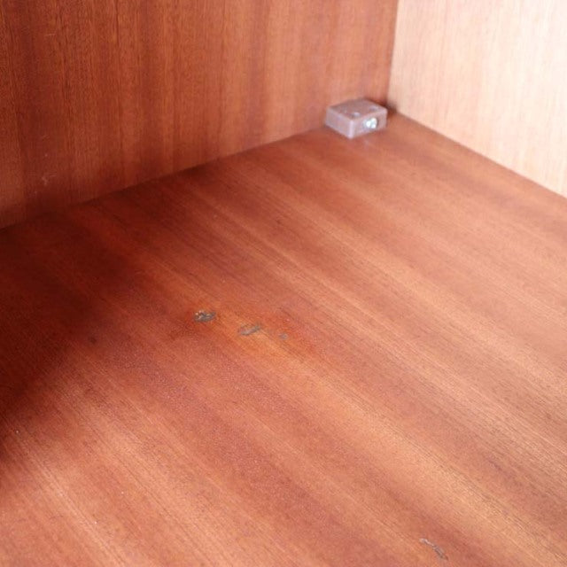 Mid-century vintage teak wood surface with rich grain, part of a British G-Plan wardrobe interior.