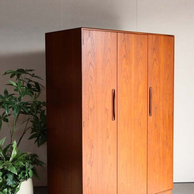 Vintage G-Plan teak wardrobe with rich wood grain, mid-century British design, featuring three doors with vertical handles.