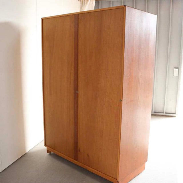 Vintage British G-Plan teak wardrobe with mid-century clean lines, smooth wood grain, and tapered legs.
