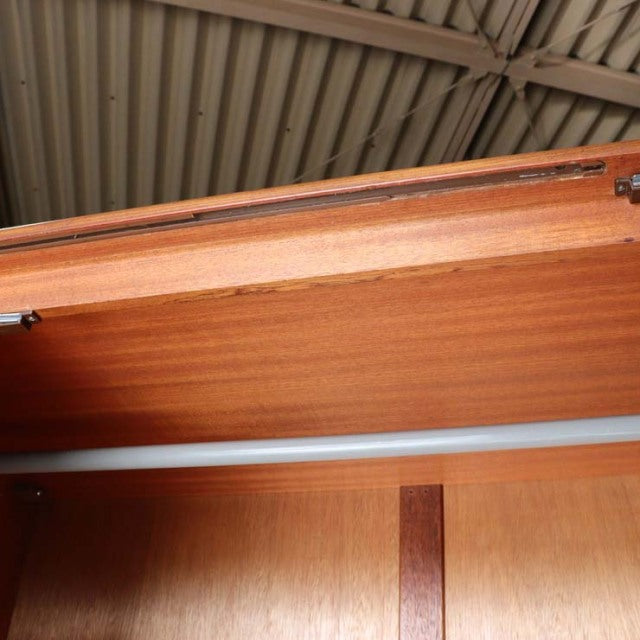Open vintage teak G-Plan wardrobe door showing smooth wood grain and mid-century British craftsmanship details.