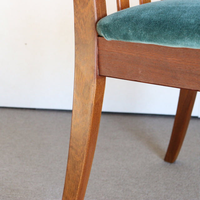 Mid-century British G-PLAN dining chair leg in teak wood with visible grain and teal green velvet seat upholstery.
