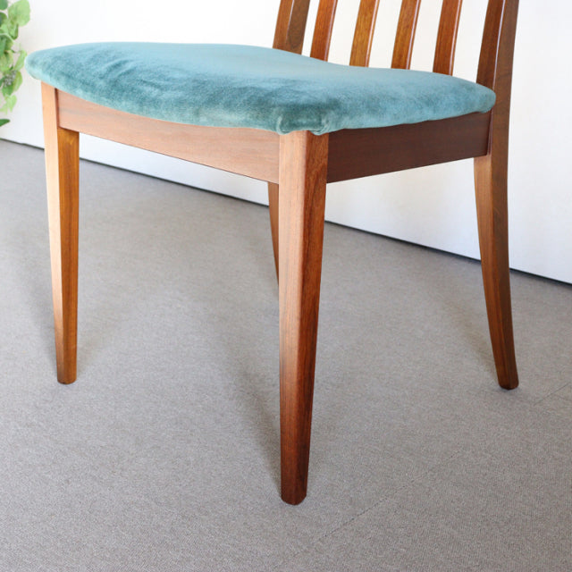Mid-century British G-Plan dining chair with teak frame and teal green upholstered seat, slender legs, and slatted backrest.