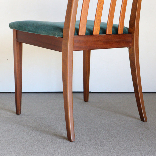 Teak mid-century British G-PLAN dining chair with teal upholstered seat, curved back slats, and angled legs.