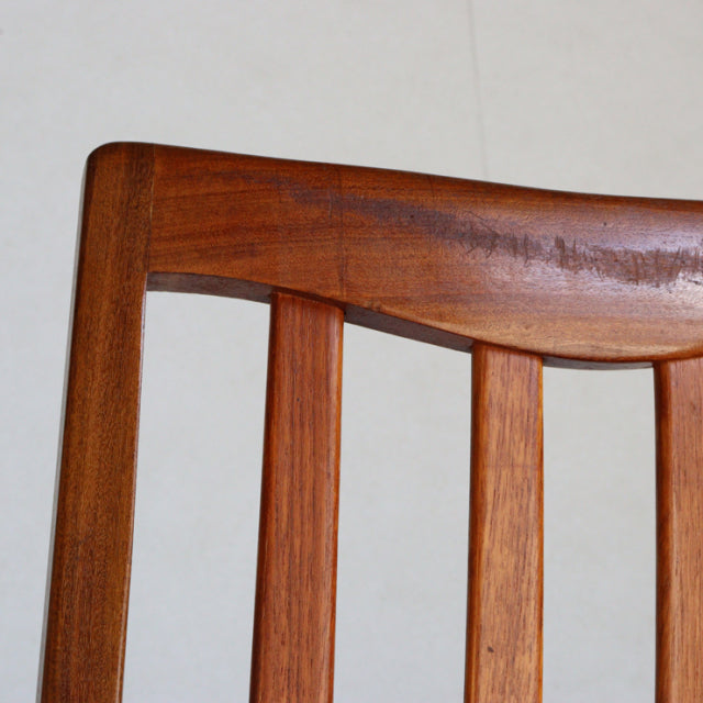 Mid-century British G-PLAN dining chair backrest in teak featuring smooth wood grain and curved top rail.