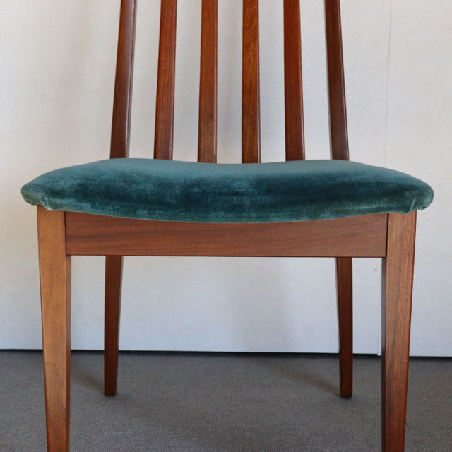Mid-century British G-PLAN dining chair in teak with vertically slatted back and teal green velvet seat cushion.