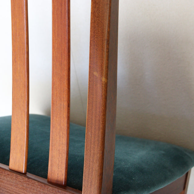 Close-up of vintage mid-century teak dining chair leg and slatted backrest with teal green upholstered seat, British G-PLAN.