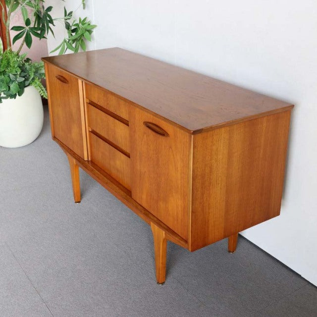 Mid-century vintage teak sideboard by Jentique with warm wood grain, tapered legs, and curved handles, British and Danish.